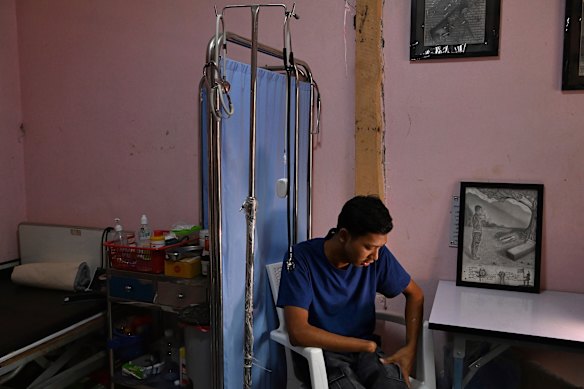 Ko Khant, que perdeu a mão direita enquanto luta contra a junta militar de Mianmar, agora voluntária nas instalações médicas subterrâneas que o trataram.